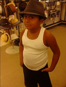 a boy wearing a hat and a tank top