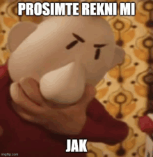 a person is holding a stuffed animal with an angry face and the words prosimte rekni mi jak written on it .