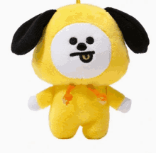 a yellow stuffed animal with a black ear and a white face