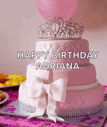 a pink birthday cake with a tiara on top of it and a bow .