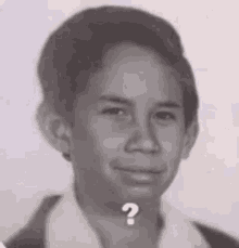 a black and white photo of a young boy with a question mark above his head .