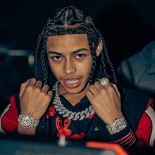 a young man with braids wearing a rolex watch and a rabbit shirt