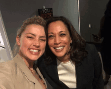 amber heard and kamala harris pose for a picture in front of a sign that says " you rock "