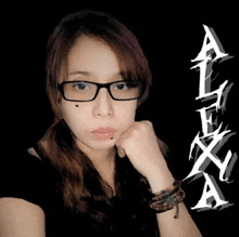 a woman wearing glasses stands in front of a black background with alexa written in white