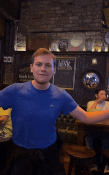 a man in a blue shirt stands in front of a sign that says irish bar