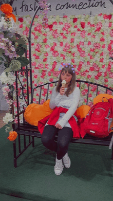 a woman is sitting on a bench eating an ice cream cone