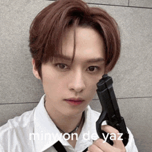 a young man is holding a gun with minwon de yaz written on the bottom