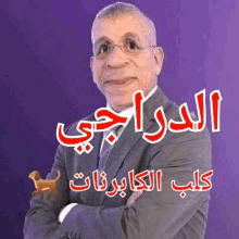 a man in a suit and tie is standing with his arms crossed in front of a purple background with arabic writing on it .