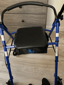 a blue walker with a black seat and a black bag