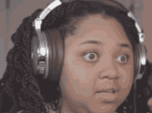 a woman wearing headphones is making a funny face .