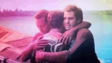 three men in spiderman costumes are hugging each other in front of a rainbow background .