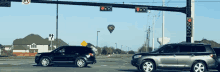 a hot air balloon is flying over a street intersection