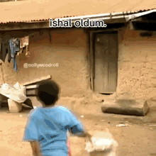 a boy in a blue shirt is standing in front of a building with the words ishal oldum above him