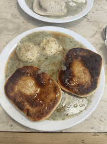 a close up of a plate of food with two pancakes and mashed potatoes