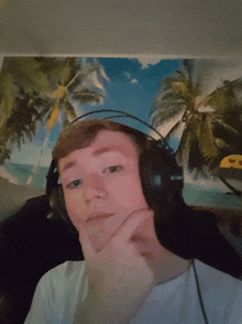 a boy wearing headphones with a picture of palm trees behind him