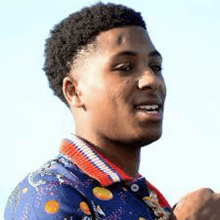 a close up of a young man wearing a blue shirt and a red and white striped collar .