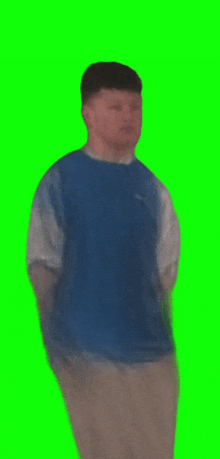 a man in a blue shirt is standing on a green screen