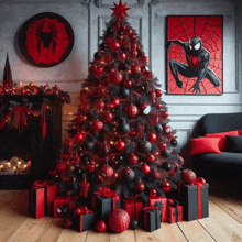 a red and black christmas tree with spider man posters on the wall behind it