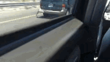 a car is driving down a highway with a van in the background