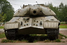 a large military tank is parked in the grass