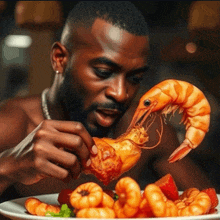 a shirtless man is eating a shrimp from a plate