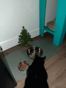 a small christmas tree sits next to a bowl of food