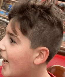 a close up of a young boy 's face with his mouth open