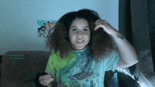 a woman with curly hair is wearing a green and yellow shirt with rick and morty on it