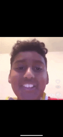 a close up of a young man 's face with a yellow shirt on looking at the camera .