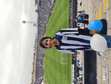 a girl in a gray and white striped shirt is holding a blue balloon