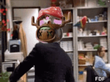 a man in a suit is wearing a reindeer mask and sunglasses .