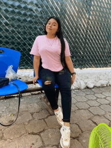 a girl in a pink shirt sits on a blue chair