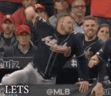 a baseball player is throwing a ball in the air in front of a crowd at a baseball game .