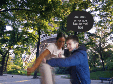 a man and a woman are dancing in a park with a speech bubble that says aii meu amor