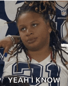 a woman with dreadlocks wearing a cowboys jersey says " yeah i know "