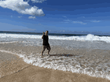 a man in a black shirt is standing on the beach