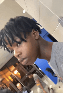 a young man with dreadlocks is standing in a room