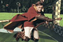 harry potter is flying through the air on a broom while playing quidditch