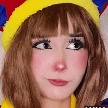 a close up of a woman wearing a clown costume with a yellow hat .