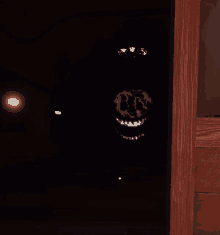 a dark room with a picture of a smiling face behind a wooden door