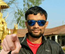 a man wearing sunglasses and a jacket that says sport on it