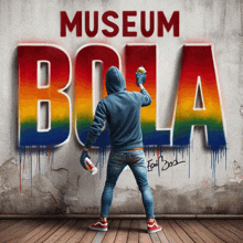 a person spray paints the word museum bola on a wall