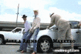 three men in cowboy hats are standing next to a silver car with the words like a rainbow in marrero written on the bottom