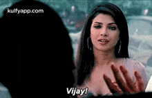 a woman is talking to a man in a car and saying `` vijay ! ''