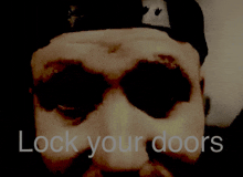 a close up of a man 's face with the words " lock your doors " below it