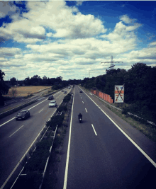 a person riding a motorcycle down a highway next to a sign that says no smoking