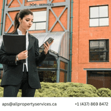 a woman in a suit is looking at her cell phone