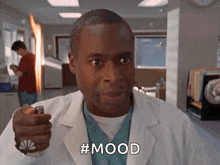 a man in a lab coat is holding a lighter and the word mood is on his face