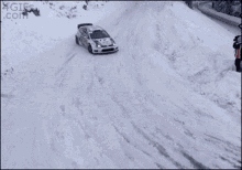 a rally car is driving through the snow and the bottom of the screen says 4gifs.com