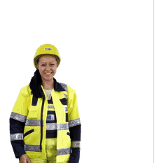 a woman in a yellow jacket holds up a yellow hard hat that says ' safety ' on the front